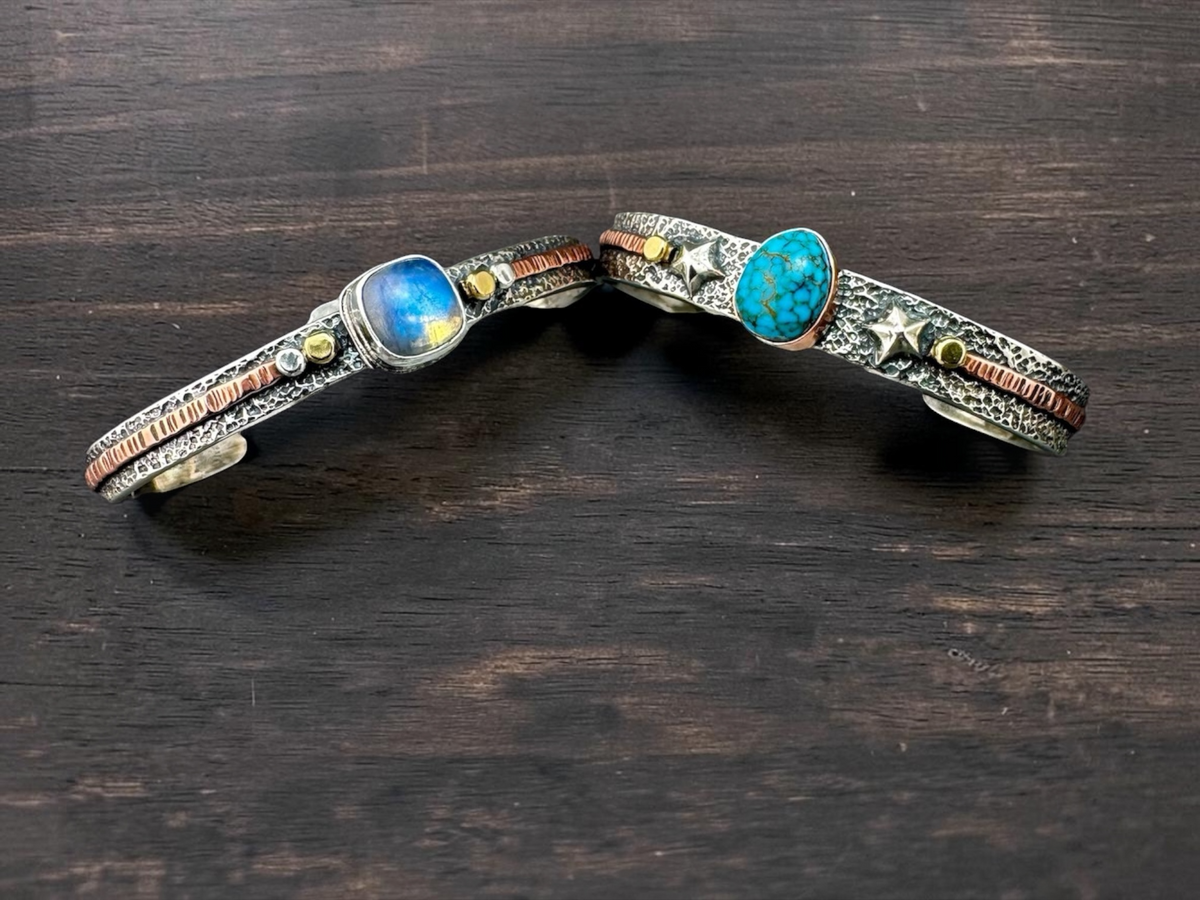 Two sterling cuff bracelets with moonstone and turquoise on wood