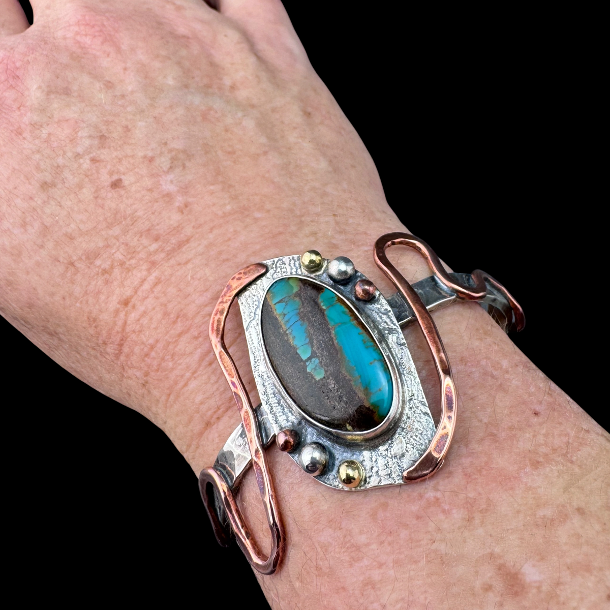 Opalized wood cuff bracelet worn on the wrist