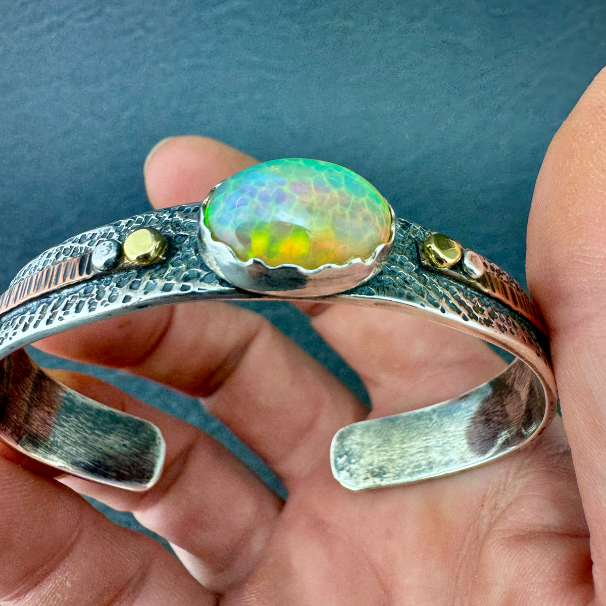 Ethiopian Opal cuff bracelet held in hand