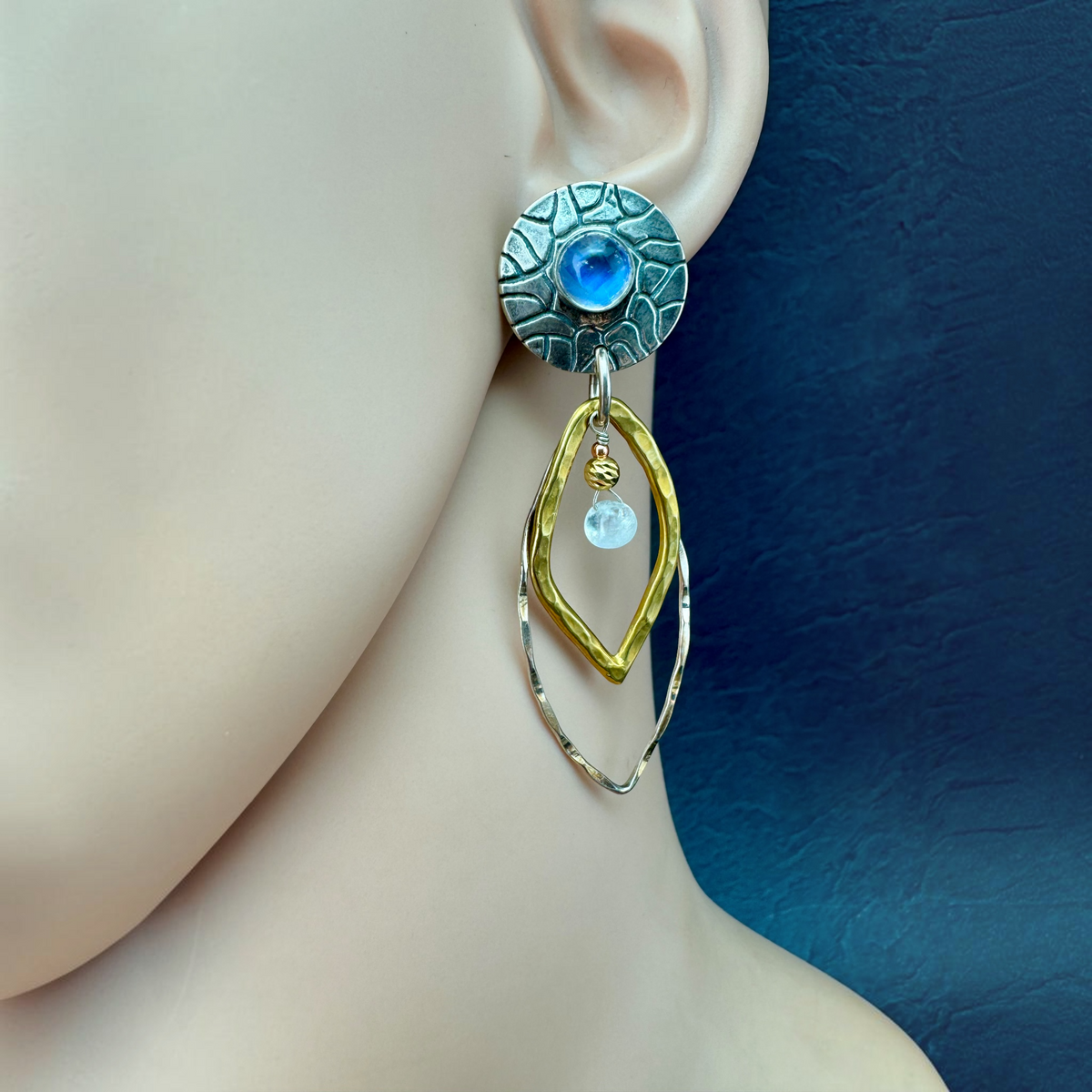 Moonstone Leaf Drop Earring shown on the ear, textured silver disc with moonstone and hammered bronze and silver leaves