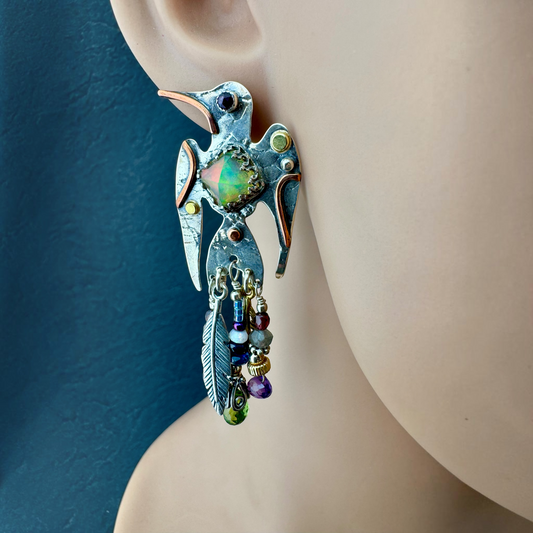 Opal and Amethyst Hummingbird Earring shown on the ear, pyramid-cut Ethiopian opal with gemstone tail feathers